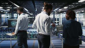 Data center engineering team doing maintenance on servers used for artificial intelligence processing. IT experts manage data center arrays used for machine learning training with tablet, camera A video