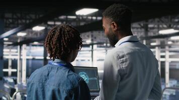 Data center team on industrial platform collaborating to maintain servers using artificial intelligence. Engineers cooperating to support infrastructure AI machine learning automatization, camera B video