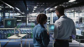 Data center team on industrial platform collaborating to maintain servers using artificial intelligence. Engineers cooperating to support infrastructure AI machine learning automatization, camera A video