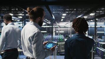Data center system administrators performing maintenance on supercomputers used for AI. Engineering team managing server hub rigs used for deep learning training, camera A video