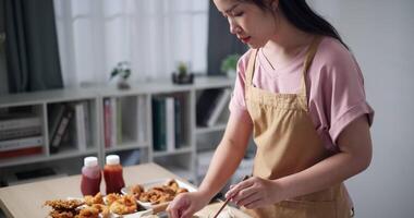 Handheld high angle view shot, Beautiful young woman tossing golden needle mushroom in a bowl of batter before frying. Woman cooking at home. Food preparation. video