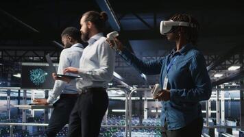 Data center admin wearing VR headset using artificial intelligence neural networks technology. Server hub developer using AI programming language and virtual reality to update hardware, camera A video