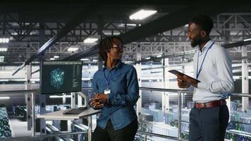 Engineers working together on data center industrial platform, completing software updates. Server hub colleagues doing brainstorming, finetuning server rig configurations, camera B video