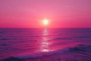 the sun is setting over the ocean in a pink sky photo