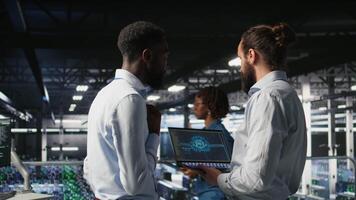 Server farm coworkers doing infrastructure AI machine learning automatization. Data center computer scientists collaborating to maintain servers using artificial intelligence, camera A video