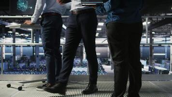 Data center system administrators collaborating to maintain servers using artificial intelligence. Teamworking colleagues doing infrastructure AI machine learning automatization, camera A video