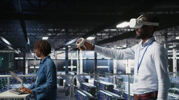 Data center admin using VR headset to monitor neural network AI systems. Server room employee using virtual reality tech to oversee equipment powering machine learning processes, camera A video