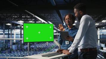 Data center engineering team coding on green screen PC, monitoring AI systems. Server hub IT coworkers use mockup computer to oversee rackmounts powering deep learning processes, camera A video