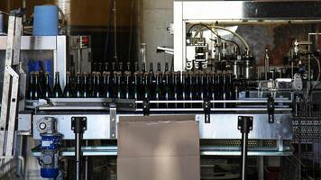Bottles of sparkling wine on a conveyor belt at a wine factory. photo