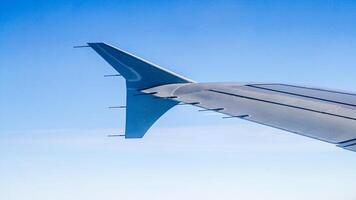 Airplane wing with a view of the blue sky from the window. photo