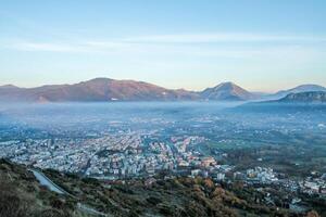Panoramic view of a mountain valley in an Italian town at dawn. photo