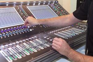 Sound engineer hands adjusting control sound mixer. Music photo