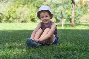 A child sits on the grass in the park photo
