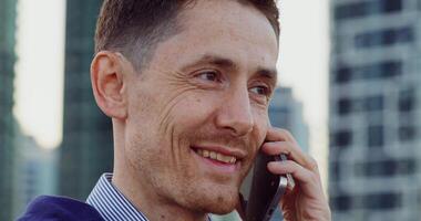 Close-up of a stylish man's face as he talks on a mobile phone while standing on a cstreet photo