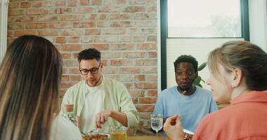 A group of young people talking and smiling while having lunch together photo