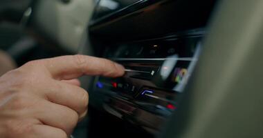 A man changes the settings of the air conditioner while driving a car. Close-up of his hands, an unrecognizable person. photo