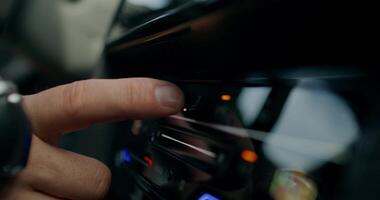 A man changes the settings of the air conditioner while driving a car. Close-up of his hands, an unrecognizable person. View from the car interior. photo