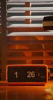A digital clock stands next to a monitor. A desktop in a retro office photo
