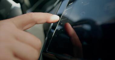 A man uses the control panel while driving a car. Close-up of his hands, an unrecognizable person. View from the car interior. photo