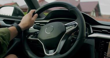 A man drives a car. Close-up of his hands on the steering wheel, an unrecognizable person. View from the car interior. Summer day photo