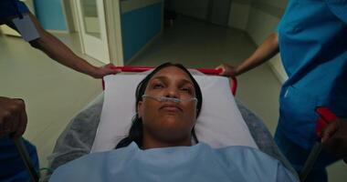 A woman with a breathing tube in her nose is lying on a gurney. photo