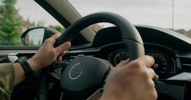 A man drives a car. Close-up of his hands on the steering wheel, an unrecognizable person. View from the car photo