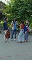 A group of young people with bags and backpacks are talking and smiling standing near the university. photo