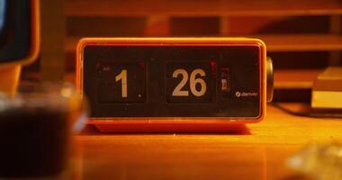 A digital clock stands next to a monitor with ripples on the screen. A desktop in office photo