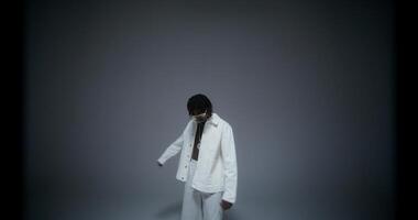 A man is dancing and singing in the studio. He looks at the camera with serious look. Recording music photo