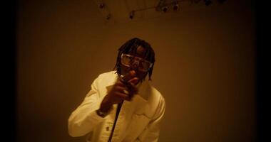 A stylish man raps while looking at the camera. Filming a musi c photo