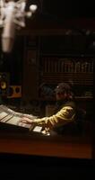 A sound engineer sits in front of an audio mixer while recording a song photo