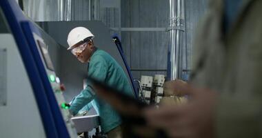 A man in protective gear works at a paper mill. He brings the stacks of cardboard photo