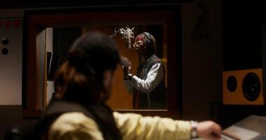 A sound engineer uses an audio mixer while recording a song in the studio. photo