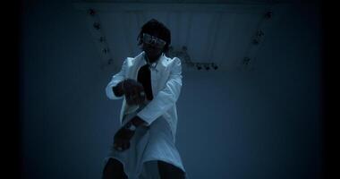An African-American man is dancing in the studio by the light of flashes. photo