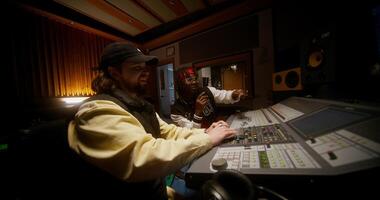 A sound engineer and a singer are discussing a recorded song in a studio. photo