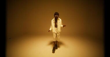 A man sings and dances in the yellow light of the studio. photo