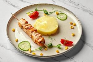 Grilled salmon skewer with mashed potatoes and vegetables on elegant plate photo