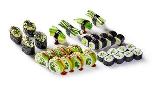 Vegan sushi set with cucumber, avocado and sesame seeds drizzled with soy sauce on white background photo