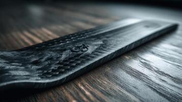 Carbon fiber sheet displaying intricate laser etching on wooden surface photo