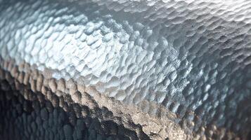 Hammered aluminum sheet showcasing intricate texture in bright light near a workshop setting photo