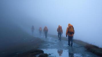 Group of hikers in reflective gear trekking through foggy terrain during an overcast day photo