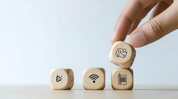 Hand Stacking Wooden Blocks with SEO, Wifi, Project Management, Goal Setting, and Contract Icons for Business Strategy photo