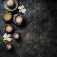 Candles and flowers sit serenely on a dark, textured stone surface, creating an ambiance of calm photo