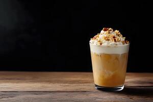 Cold coffee drink with whipped cream and chopped nuts stands on a rustic wood surface photo