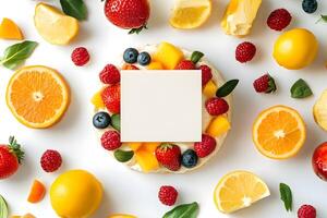Colorful citrus fruits and berries surround a blank white card on a bright surface photo