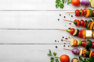 Colorful vegetable skewers are arranged on a clean white wooden surface for a flat lay composition photo