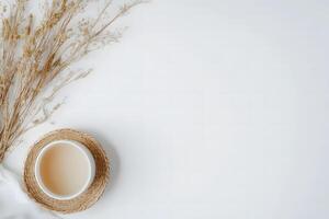 Dry grass alongside white bowl and straw mat create a serene minimal still life photo