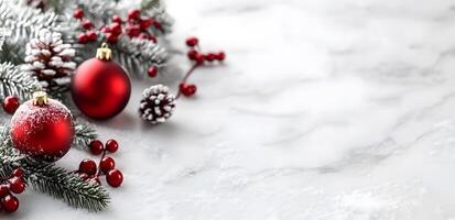 Festive red ornaments and snowy pine branches gracefully adorn a pristine white marble surface photo