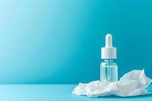 A glass dropper bottle stands on a white crumpled cloth against a blue backdrop photo