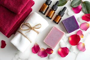 Stacked towels, essence bottles, colorful soap, and rose petals are arranged on marble photo